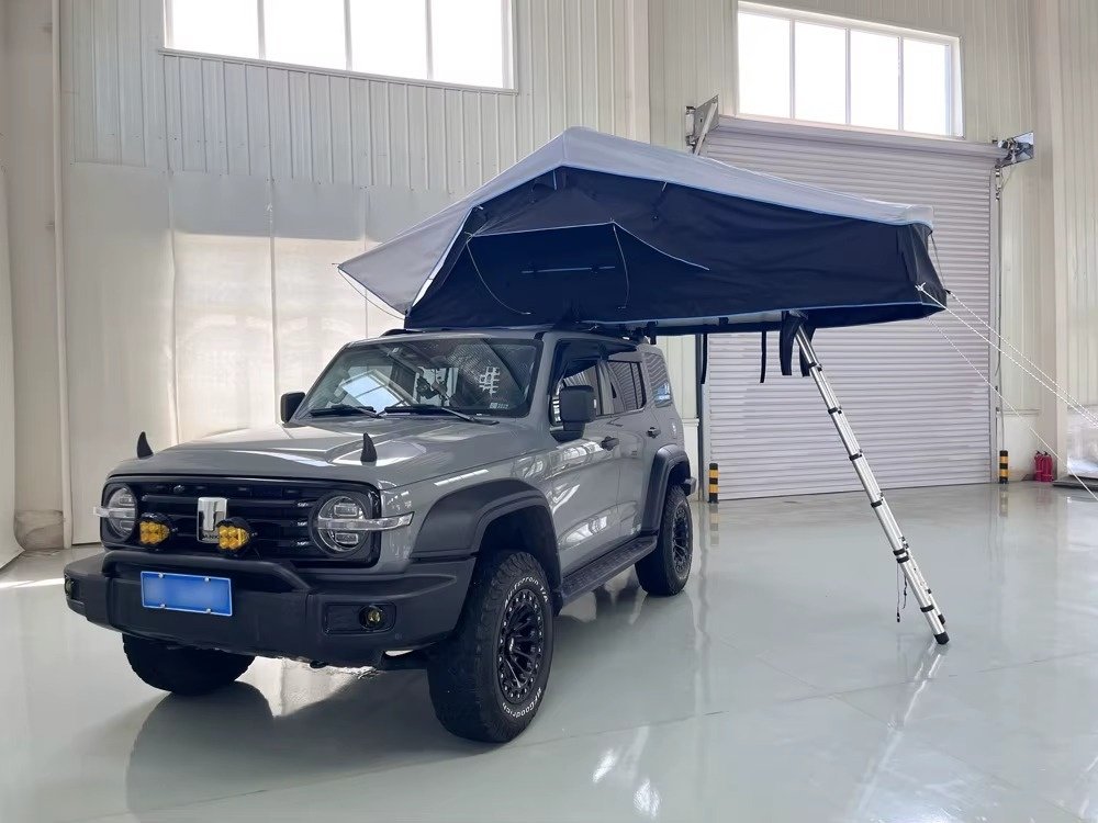 Open soft shell rooftop tent mounted on 4WD vehicle for camping