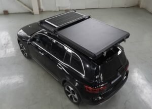 Closed hard shell rooftop tent with solar panel on SUV roof