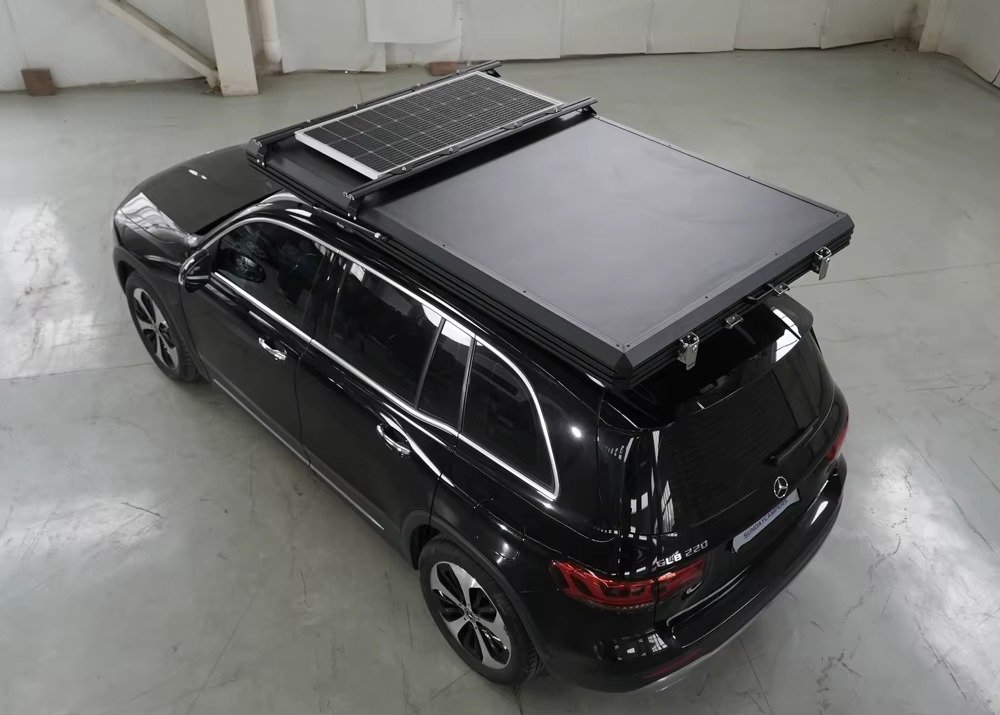 Closed hard shell rooftop tent with solar panel on SUV roof
