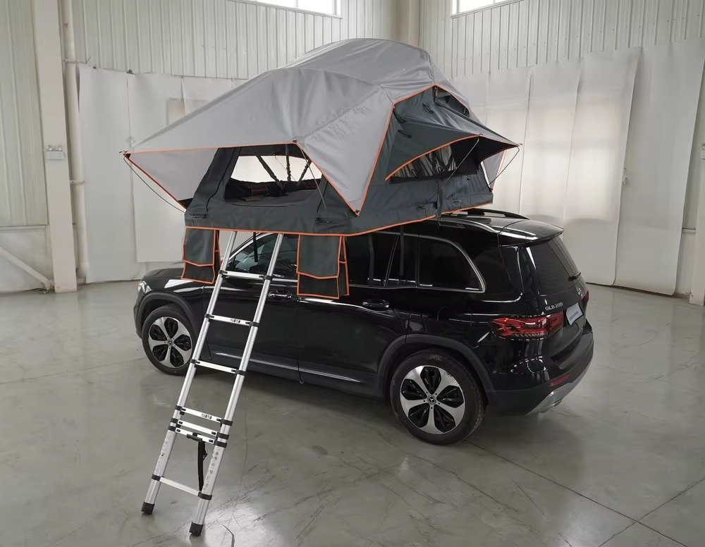 Foldable soft shell rooftop tent mounted on SUV for camping