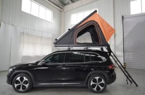 Side view of hard shell rooftop tent mounted on SUV