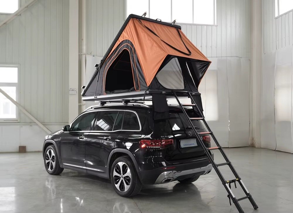 Open rooftop tent with ladder installed on SUV for camping