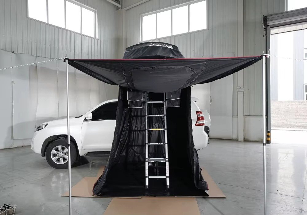 SUV camping awning extended with support poles to create a sheltered outdoor living area