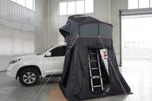 Rear view of an SUV camping tent with ladder access and an enclosed ground-level shelter