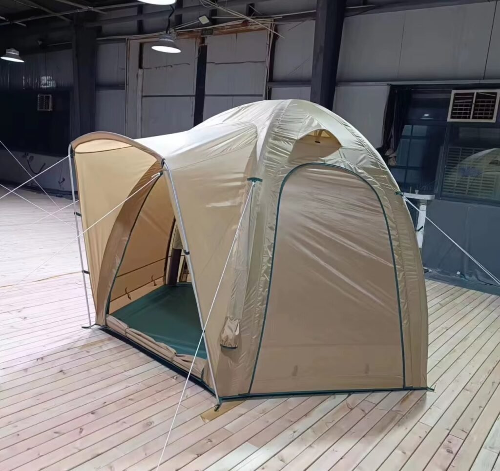 Three-quarter side view of a beige inflatable camping tent with an extended awning and side panel.