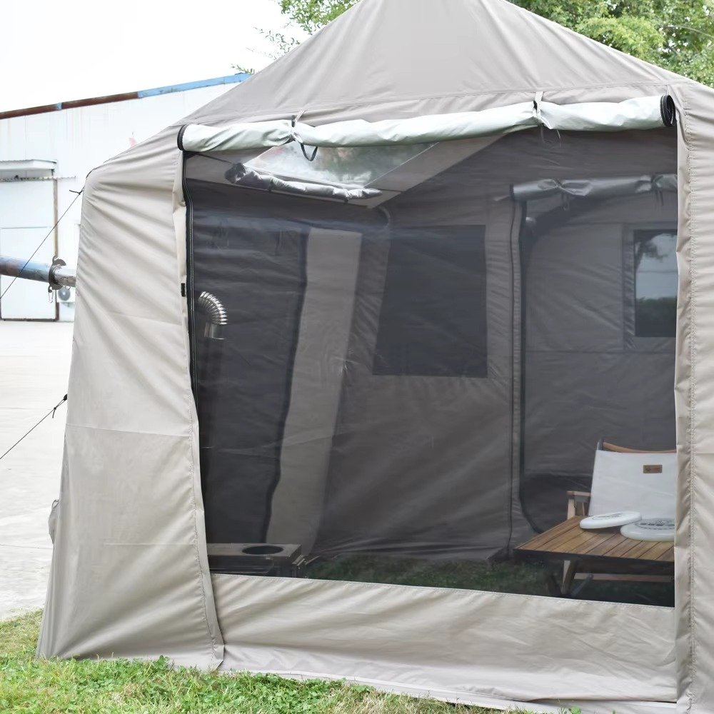 Large mesh panel across the front of a beige camping tent with camping furniture visible inside.