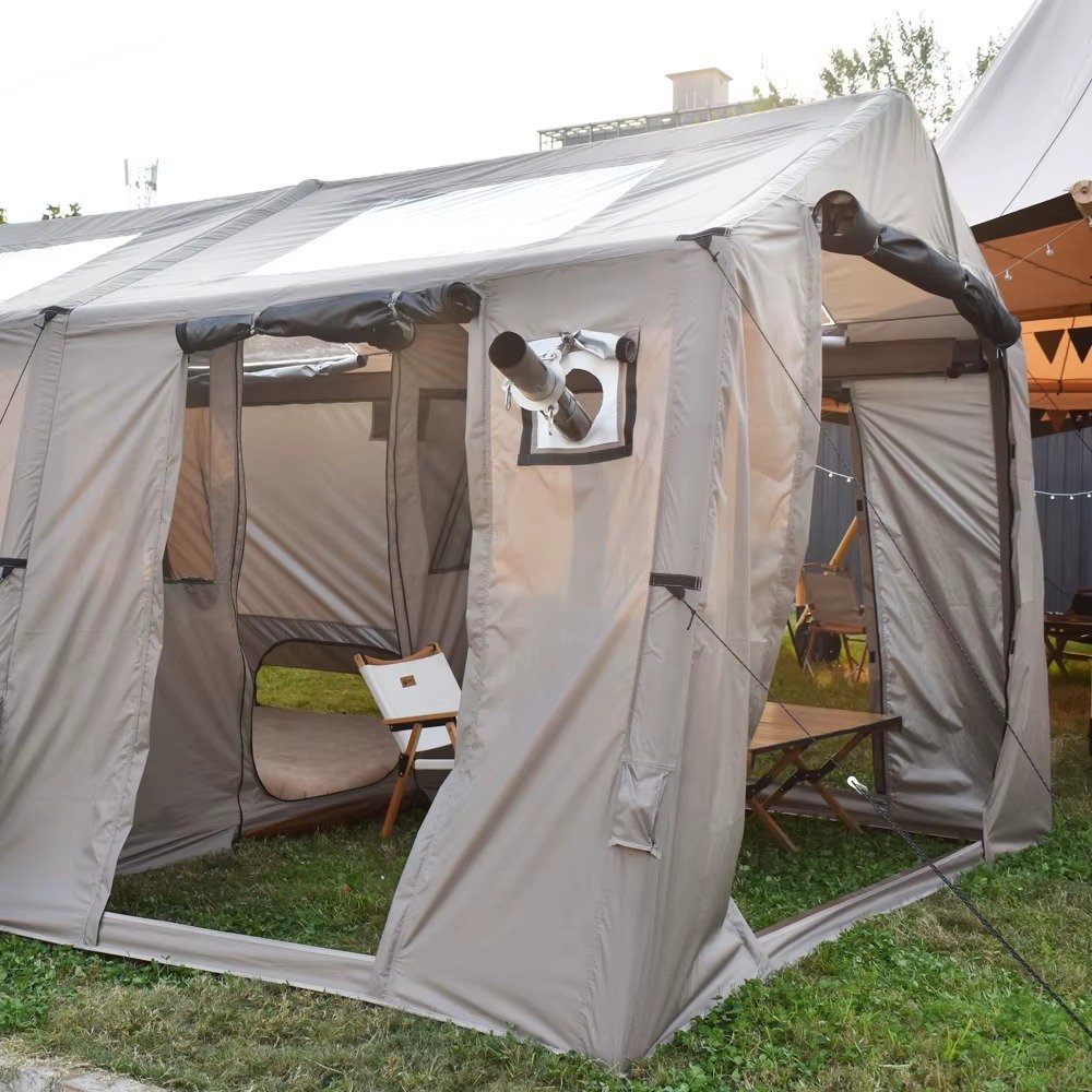 Large beige camping tent with open entry panels and a stove pipe port on the side.