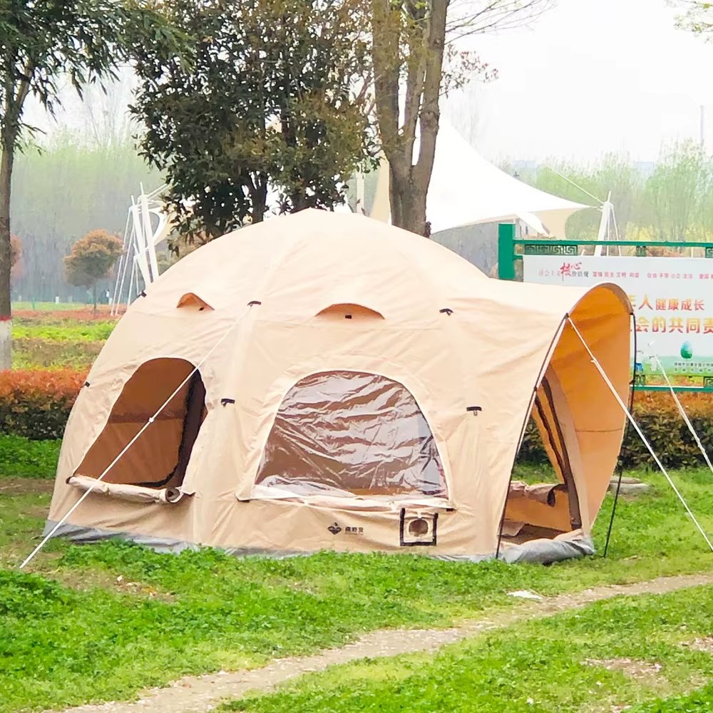 Side view of a beige family air dome tent with open entrances and window panels on a lawn