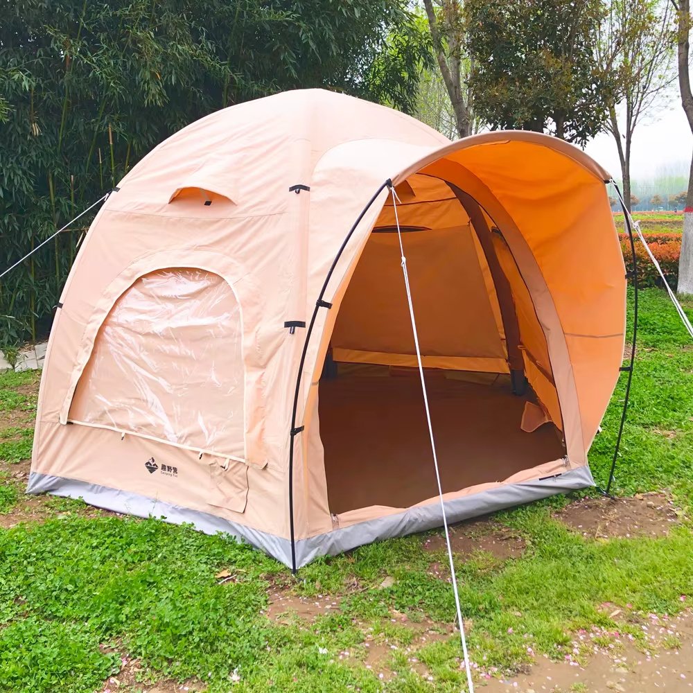 Beige inflatable air dome tent photographed from the front side with the entrance open