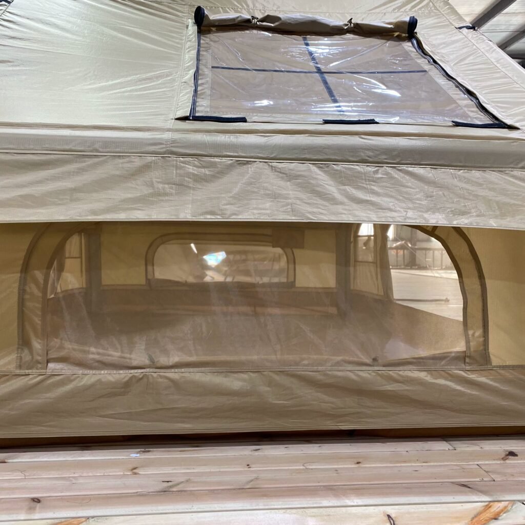 Close-up of a clear window panel on the beige tent fabric.