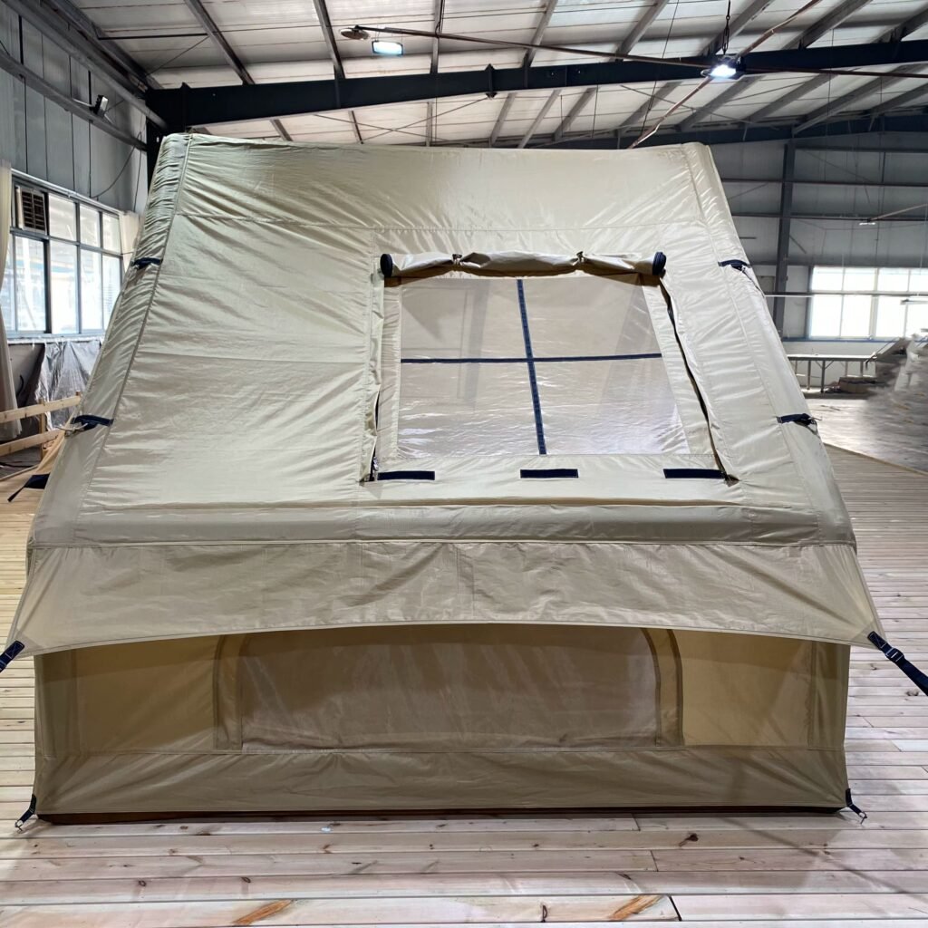 Close-up of a mesh side window with a rolled fabric cover on a beige inflatable tent.