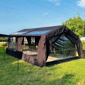 Black cabin tent with blue roof skylight panels and large mesh windows in an outdoor setting.