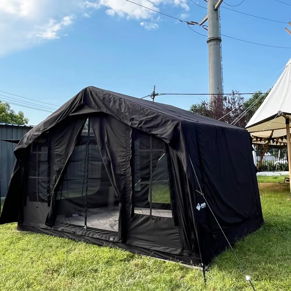 Dark tent with an open front entrance and mesh panels on grass