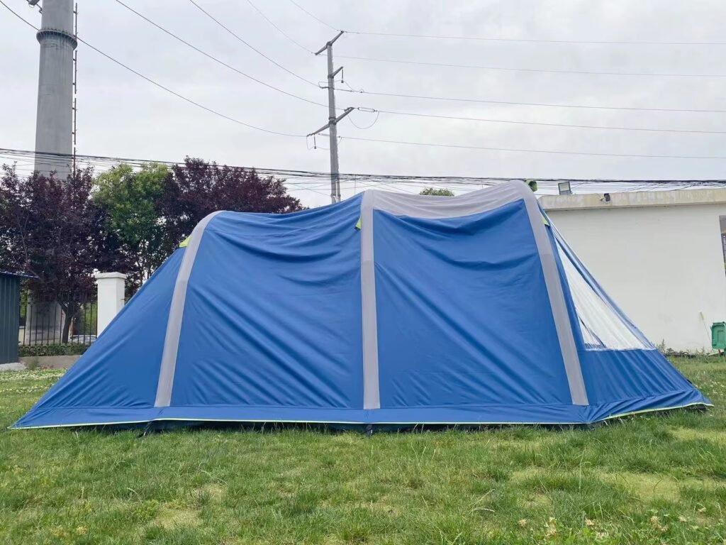 Blue and gray inflatable tent pitched on grass in an outdoor setting.