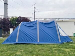 Blue and gray inflatable tent pitched on grass in an outdoor setting.