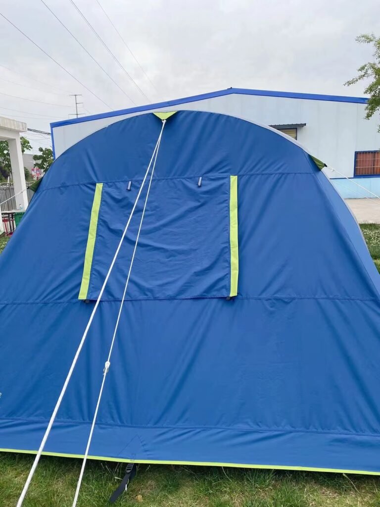 Close view of a blue tent panel with a small fabric flap and guyline.