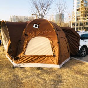 Brown and beige camping tent beside a parking area and city buildings