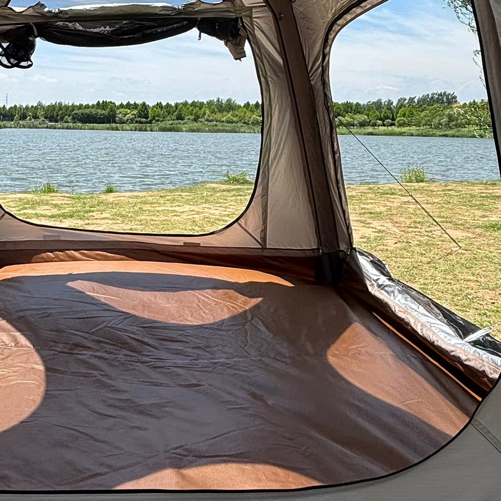 View from inside a tent toward the lake through large open window panels