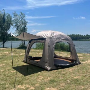 Beige camping tent with an extended awning and mesh doorway beside a lake