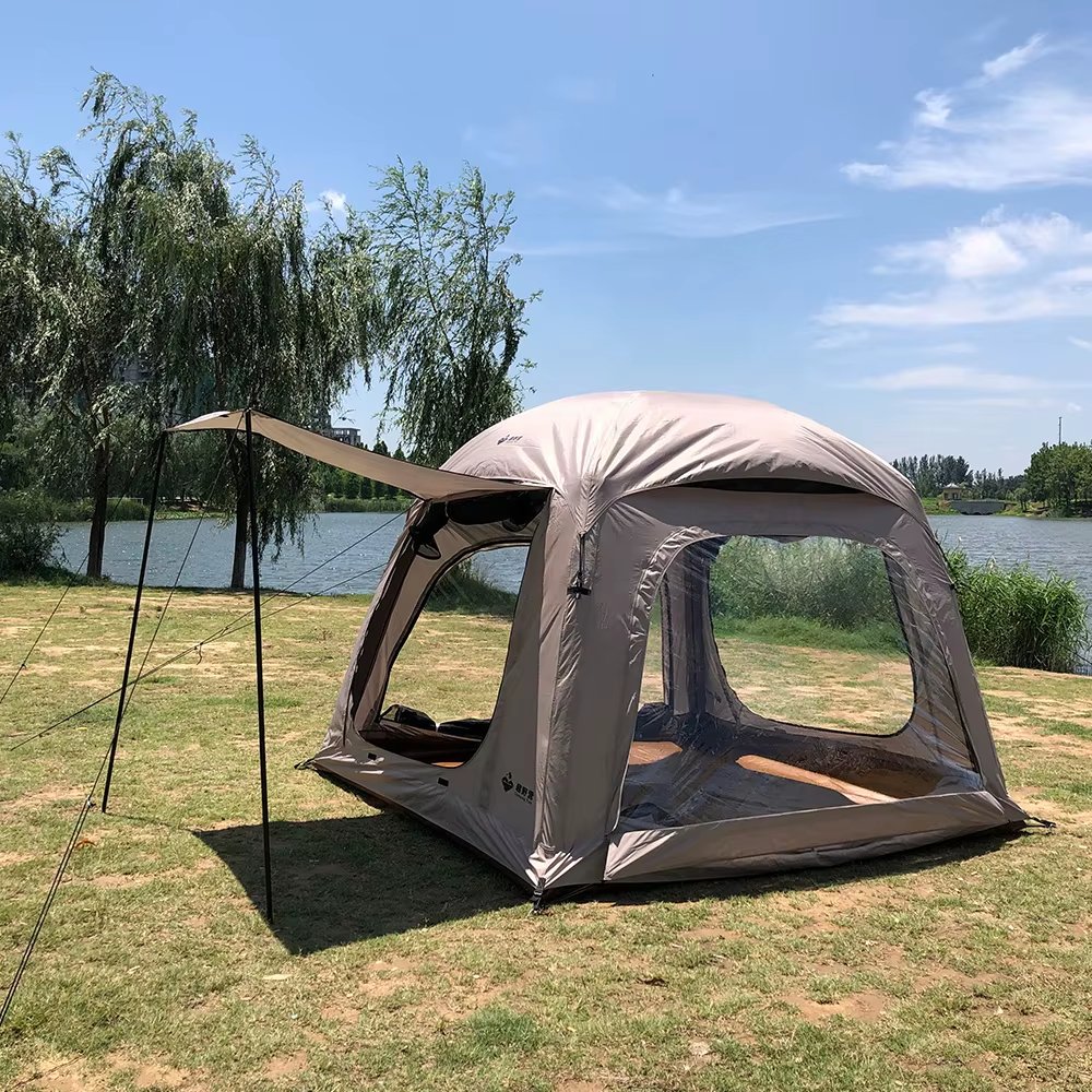 Side view of a beige tent with an extended awning and large mesh windows
