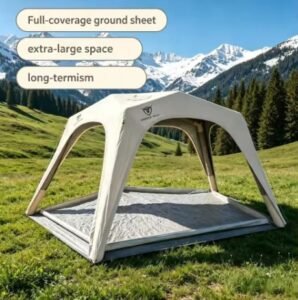 Light-colored outdoor shelter with a full-coverage groundsheet and extended shade area set up in a mountain meadow.