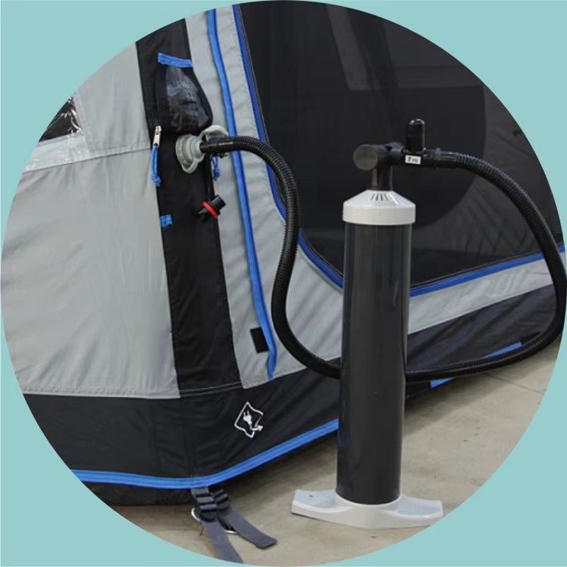 Floor pump connected to the inflation valve of a gray and blue inflatable camping tent.