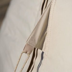 Close-up of a guyline attached to the reinforced fabric of a beige teepee tent.
