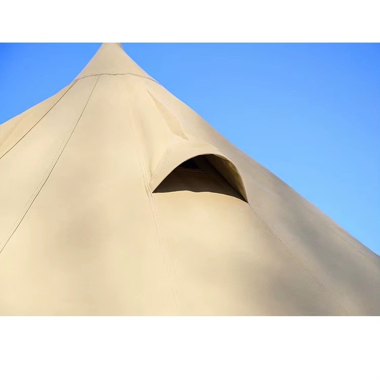 Close-up of a covered ventilation opening on the roof of a beige teepee tent.